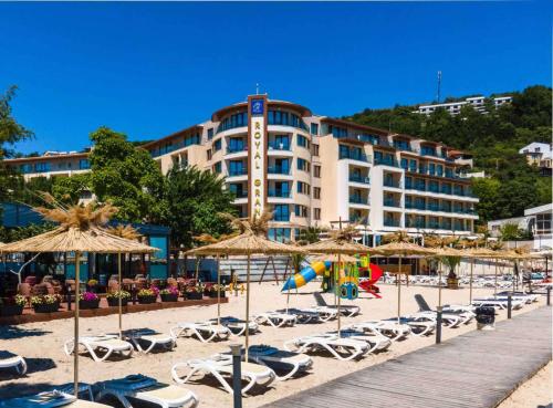 a beach with chairs and umbrellas and a hotel at Royal Grand Hotel and Spa - All Inclusive and Free beach accsess in Kavarna