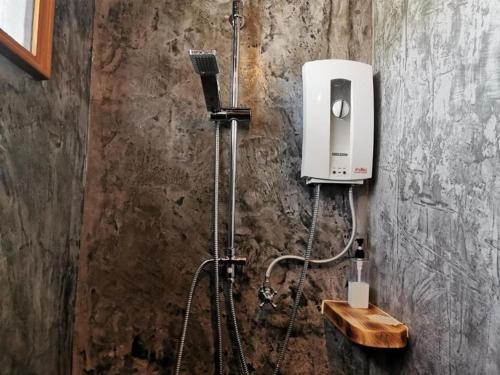 a bathroom with a shower with a soap dispenser at BaanMee Phuket SHA Plus in Chalong 