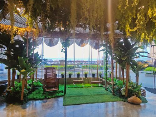 a living room with a large window and plants at Ramada Foshan Hotel in Foshan