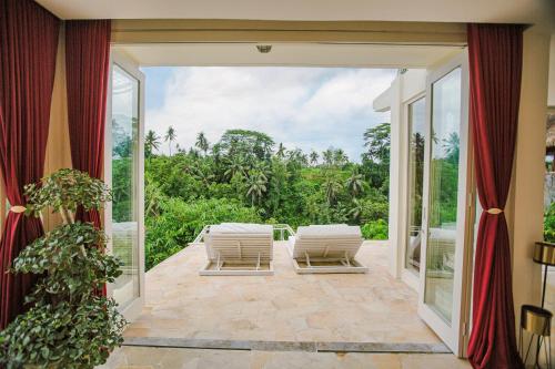 an open door to a patio with chairs and a view at Villa Cella Bella Ubud in Ubud