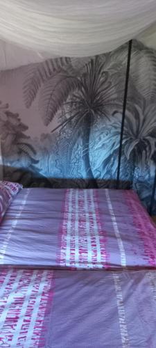a bed with a purple comforter and a wall at Ferienwohnung Jarenatanne in Stockach