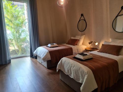 een hotelkamer met 2 bedden en een groot raam bij Peaceful Ocean Terrace in Funchal