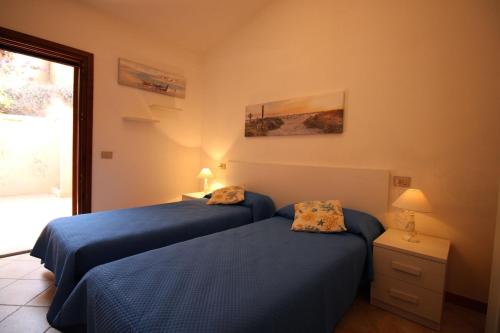 sypialnia z dwoma łóżkami i oknem w obiekcie Casa Mira con piscina e bellissima vista mare w mieście Costa Paradiso