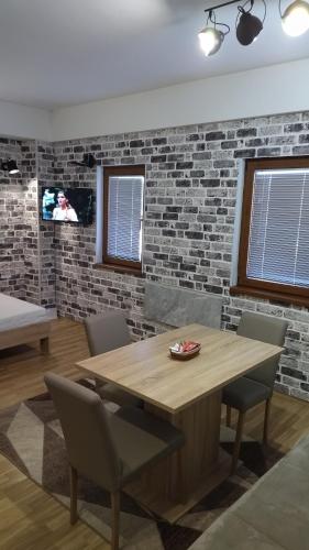 a dining room with a wooden table and chairs at Mavrovo Kjara Apartments in Mavrovo