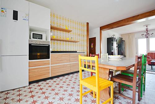 cocina con mesa, sillas y nevera en Espacioso apartamento en Cambados, en Cambados