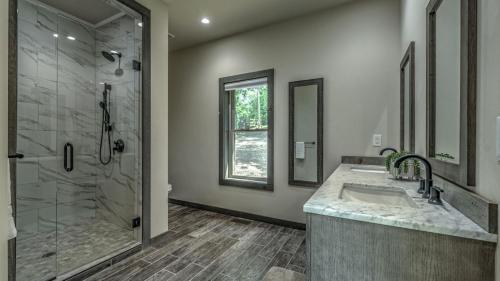a bathroom with a shower and a sink and a mirror at Whitetail Bluff in Mineral Bluff