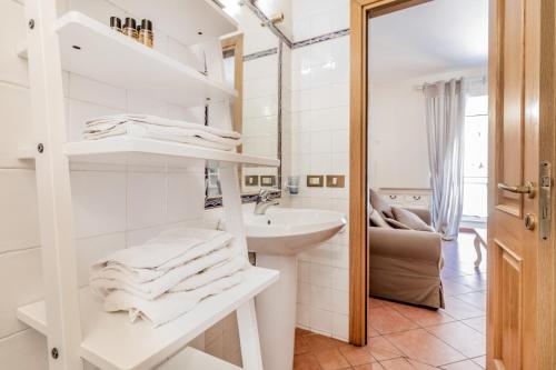 W białej łazience znajduje się umywalka i lustro. w obiekcie When in Trastevere w Rzymie