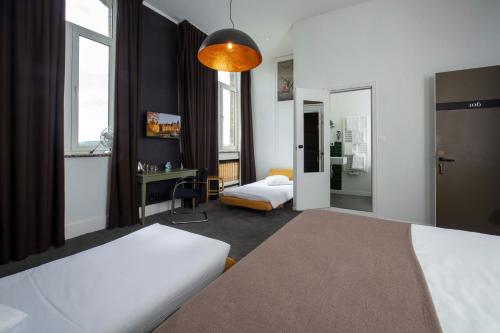 a hotel room with two beds and a desk at Domaine de Ronchinne - Château et Ecuries in Maillen