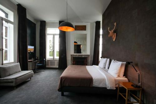 a bedroom with a bed and a couch and a chair at Domaine de Ronchinne - Château et Ecuries in Maillen