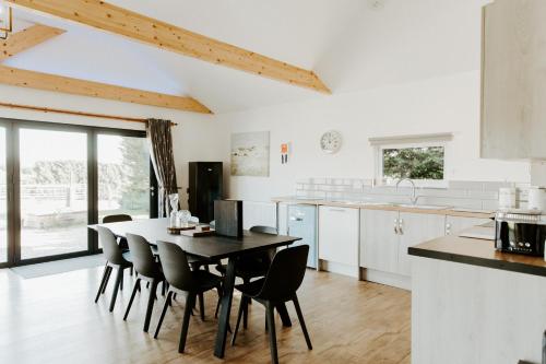 a kitchen with a dining room table and chairs at King Richard's Luxury Lodge - Sleeps up to 8, Dog Friendly, Near Sherwood Forest at Fairview Farm in Nottingham set in 88 acres and great for Groups, Family Gatherings & Corporate events in Nottingham