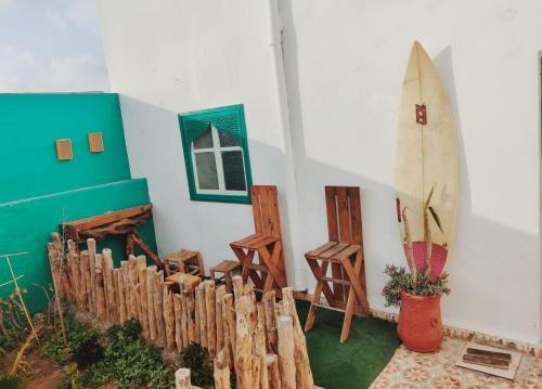 een kamer met een surfplank tegen een muur bij Thayri Hostel in Sidi Kaouki