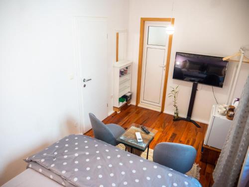 a living room with a bed and a table and a television at ~Melody Room ~ with Breezy & Silent Ambience in Hvar
