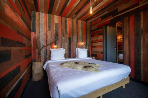 a bedroom with a bed in a room with wooden walls at Domaine de Ronchinne - Château et Ecuries in Maillen