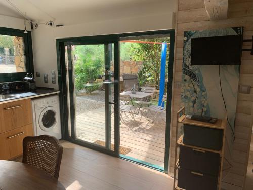 d'une cuisine avec une porte coulissante en verre s'ouvrant sur une terrasse. dans l'établissement Cabanon, à Sanary-sur-Mer