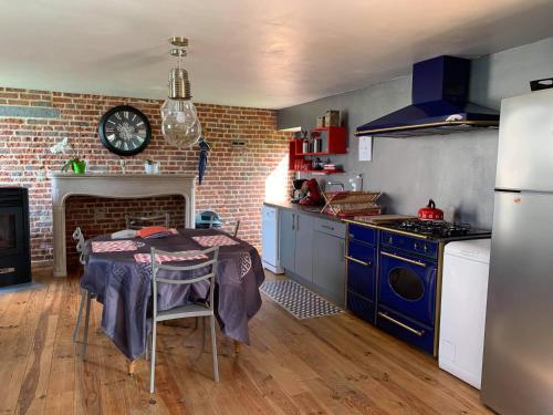 a kitchen with a table and a brick wall at Gîtes du Grand Bois in Maubeuge