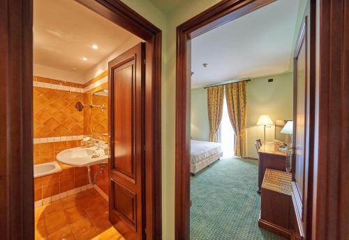 a bathroom with a bed and a sink and a tub at Relais Santo Stefano in Sandigliano