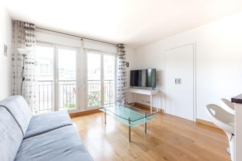 un salon avec un canapé et une table en verre dans l'établissement Earth Center by Plaza - Proche Disneyland Paris, à Chessy