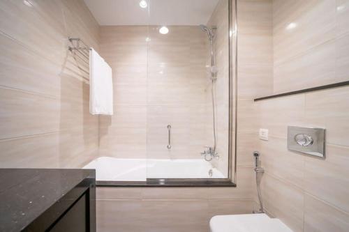 a bathroom with a bath tub and a toilet at Frank Porter - DAMAC Celestia in Dubai