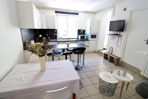 une cuisine avec une table et des chaises dans une pièce dans l'établissement Villa Berthe Coeur du Touquet, à Le Touquet-Paris-Plage