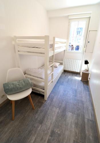 - une chambre avec 2 lits superposés et une chaise dans l'établissement Villa Berthe Coeur du Touquet, à Le Touquet-Paris-Plage