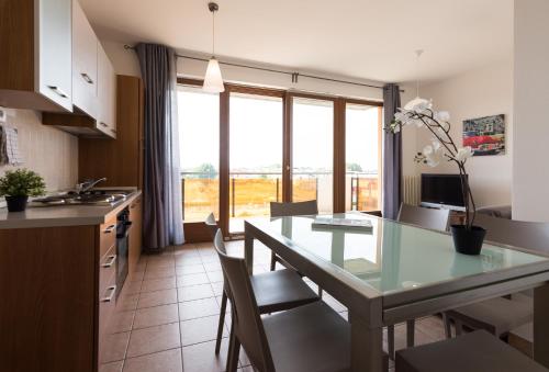 a kitchen and dining room with a glass table at Gardappartamenti Benacus Sirmione in Sirmione