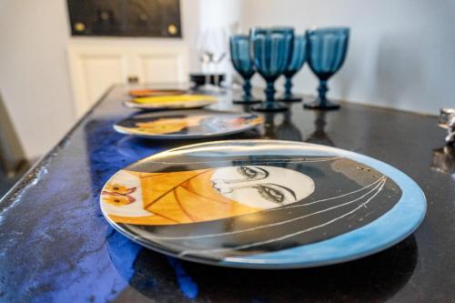 a table with three plates and two wine glasses at Dimora Bormioli in Bari