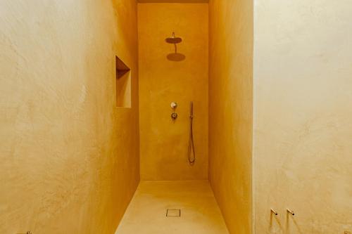 a bathroom with a shower in a yellow wall at Dimora Bormioli in Bari