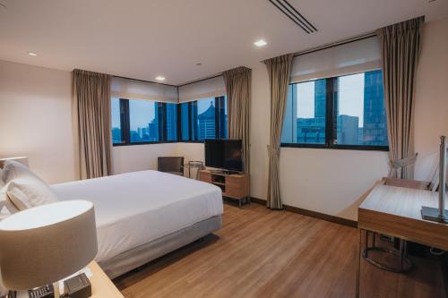 Novotel Living Singapore Orchard tesisinde bir odada yatak veya yataklar
