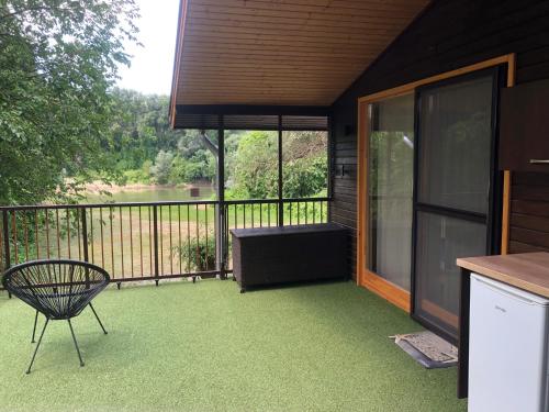a screened in porch with a table and a chair at Bárka a Tiszához apartman in Tiszaug