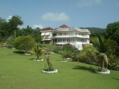 un gran edificio blanco con árboles delante de él en Barhanna Vista Lodge, en Port Antonio