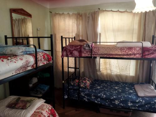 a room with three bunk beds and a window at El Hostal in Tbilisi City