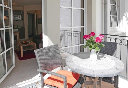 a table with a vase of roses on a balcony at Haus Meeresblick - Ferienwohnung Lachmoewe A 1.35 (Ref. 162722 u 1) in Baabe