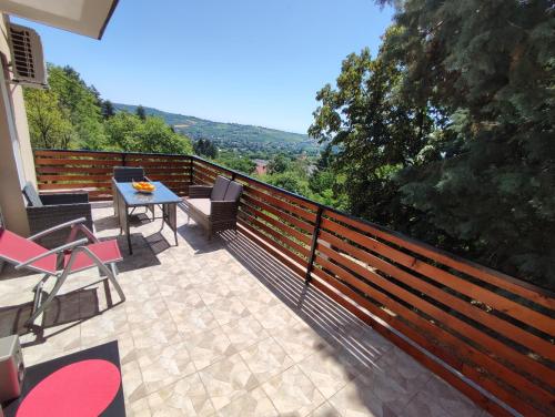 un patio con tavolo e sedie sul balcone. di Miličin konak a Vrdnik