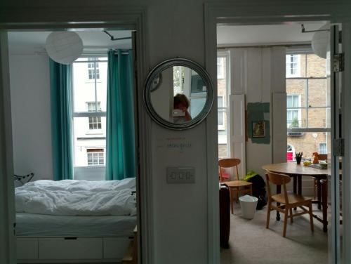 a woman in a mirror in a room with a bed at Central London flat. Georgian Terrace. Bright. in London