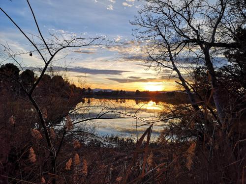 a sunset over a lake with the sun setting at Apartamento Palacio de los Toledo in Corella
