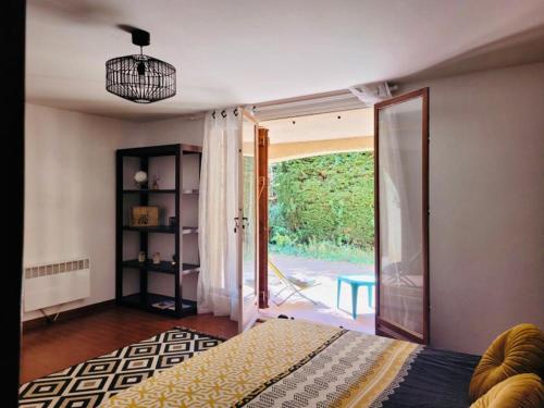 une chambre avec un lit et une porte coulissante en verre dans l'établissement BOULOURIS, Grand Studio 2 à 4 personnes à 5min à pied des plages, à Saint-Raphaël