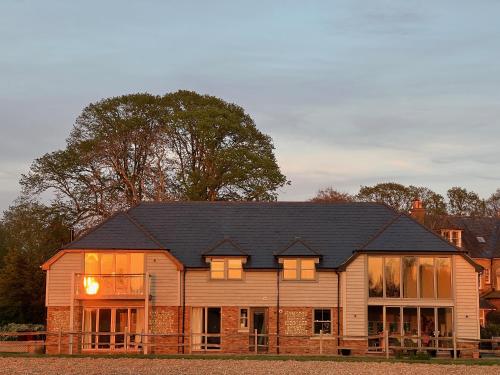 ein großes Holzhaus mit schwarzem Dach in der Unterkunft Flint House - Goodwood Events in Chichester