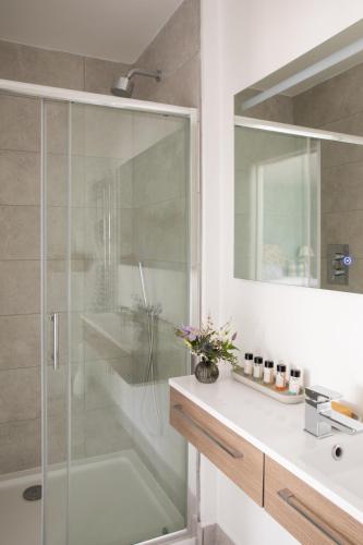 a bathroom with a glass shower and a sink at Flint House - Goodwood Events in Chichester