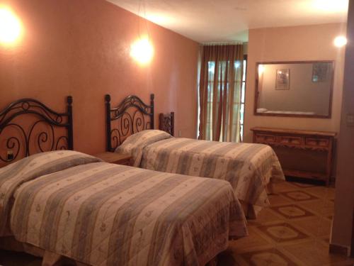 Un pat sau paturi într-o cameră la Hotel Hacienda Prom