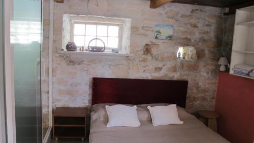 a bedroom with a bed with two pillows and a window at Guesthouse Ursic in Selca