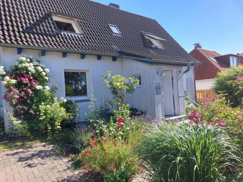 een wit huis met bloemen ervoor bij Haus Sonnenlicht. Idylle am Ratzeburger See! in Ratzeburg