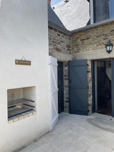 a garage with a blue door and a building at le coin des hirondelles in Pontorson