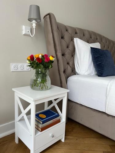 a vase of flowers on a table next to a bed at Appartement d exception 100m2 avec Parking - Centre historique in Chambéry