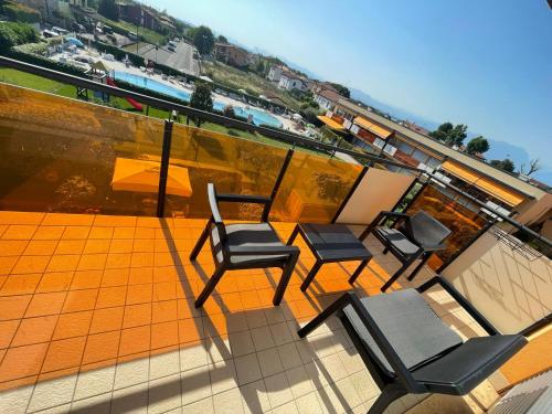 three chairs and a table on the roof of a building at Gardappartamenti Benacus Sirmione in Sirmione