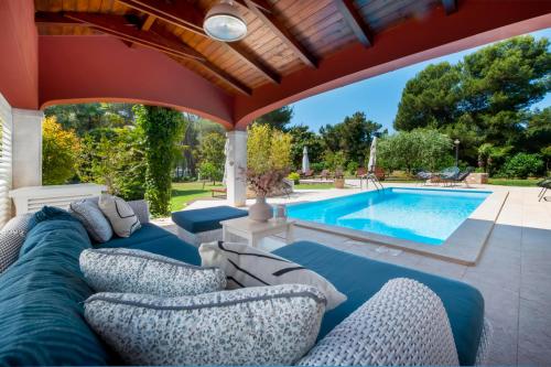 a patio with blue couches and a swimming pool at Apartments Villa Rossella 1 in Rovinj