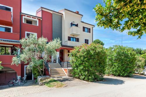 a red and white building with stairs and trees at Apartments Villa Rossella 1 in Rovinj