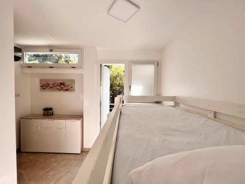 une chambre blanche avec un lit et une fenêtre dans l'établissement APPART/PALM BEACH/ CANNES, à Cannes