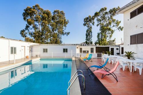 uma piscina com cadeiras e uma mesa em Live, Laugh, Love Beach Guest Home with AC na Madalena