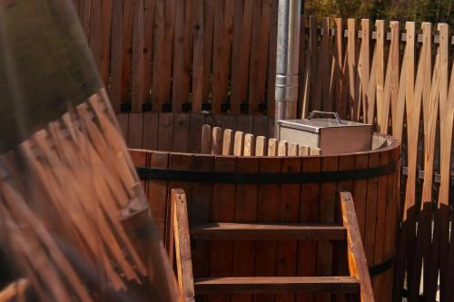 a wooden fence with two chairs and a tub at Glamping Village in Sarpi