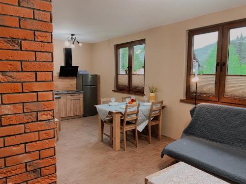 a kitchen and dining room with a table and chairs at Świerkowe Domki Cisna in Cisna